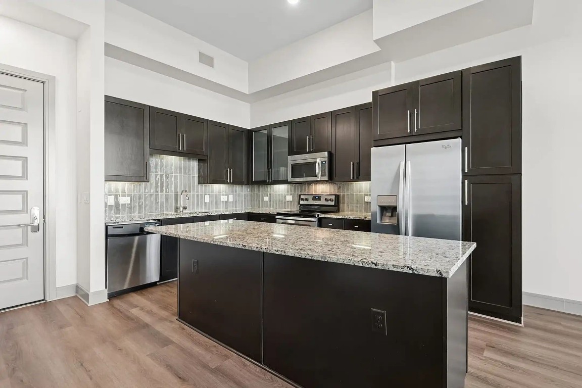 2724 Kipling Street, Unit 308 Houston, TX 77098 - Photo 26 of 29 a kitchen with stainless steel appliances granite countertop a refrigerator a stove a sink and a microwave