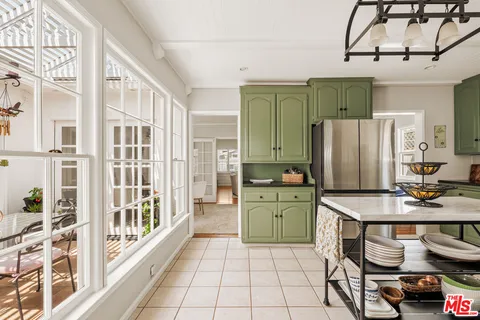 a kitchen with stainless steel appliances a refrigerator a sink a stove and white cabinets