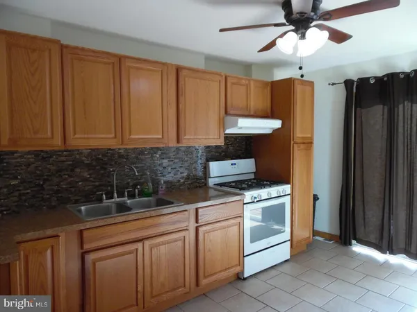 a kitchen with stainless steel appliances granite countertop a stove a sink and a refrigerator with wooden cabinets