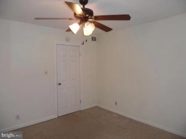 an empty room with a chandelier fan