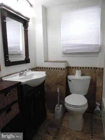 a bathroom with a sink a toilet and mirror