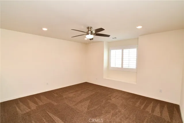 a view of a livingroom with a ceiling fan and window