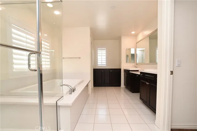 a large bathroom with a double vanity sink a mirror and a shower