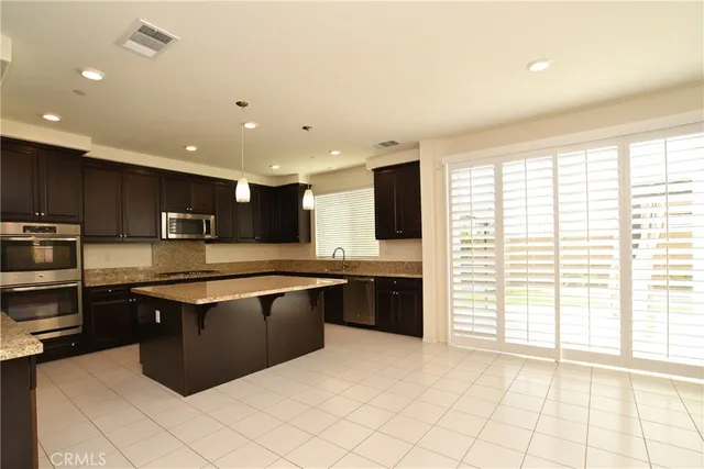 a large kitchen with stainless steel appliances granite countertop a stove and a sink