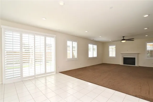 a view of an empty room with a window and fireplace