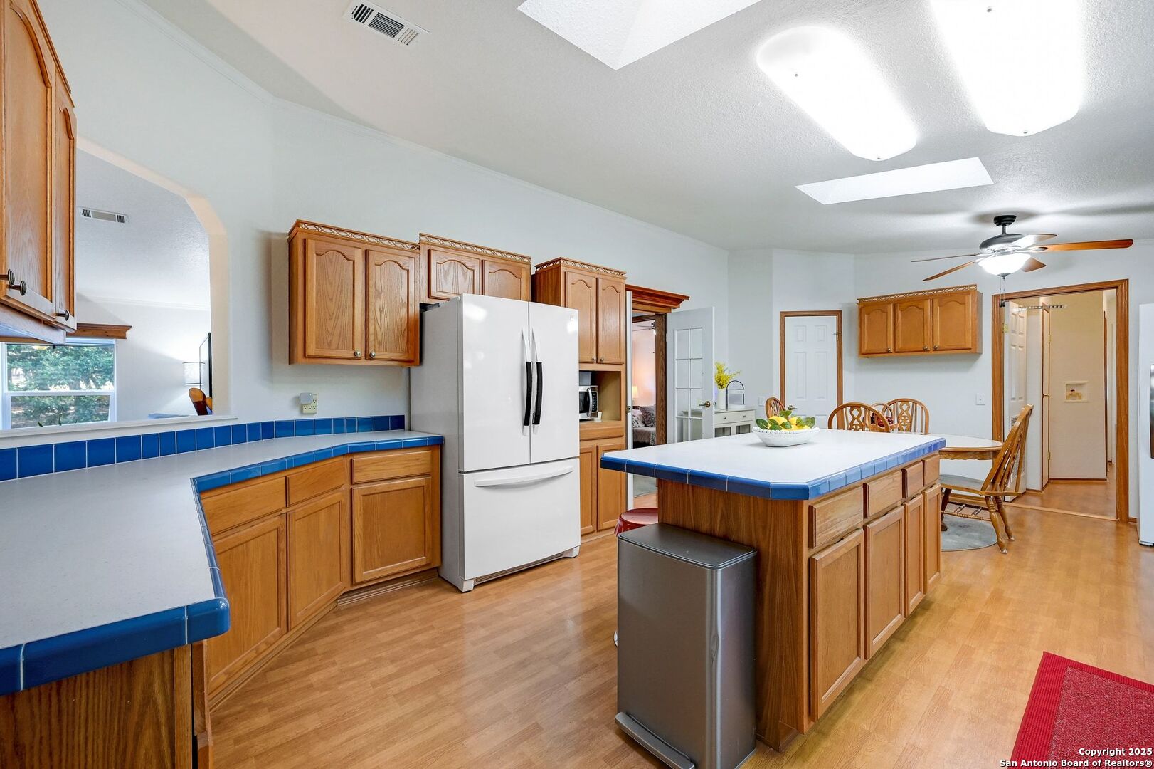 480 Rangeland Road Blanco, TX 78606 - Photo 7 of 26 a kitchen with stainless steel appliances a stove a refrigerator a sink dishwasher and wooden cabinets with wooden floor