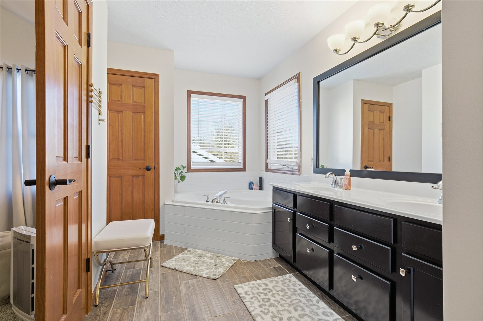 1504 Estate Drive Normal, IL 61761 - Photo 19 of 34 a bathroom with a tub a sink and a large mirror