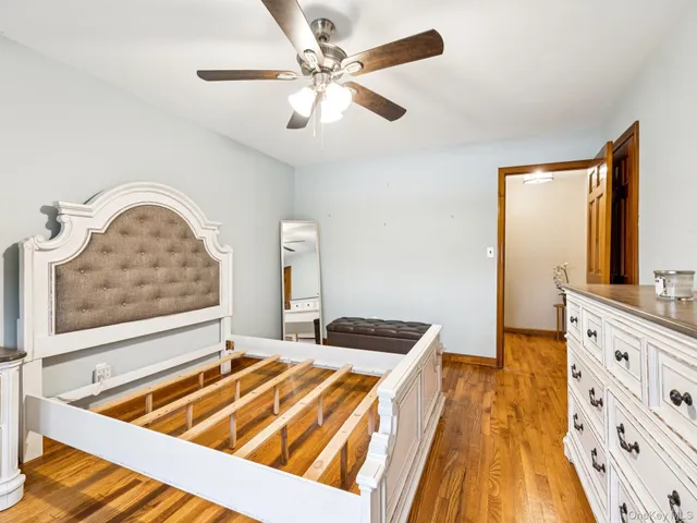 a bedroom with a bed and a flat tv screen on dresser