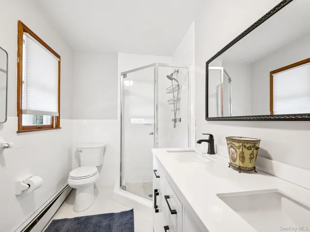 a bathroom with a sink a toilet and a large mirror
