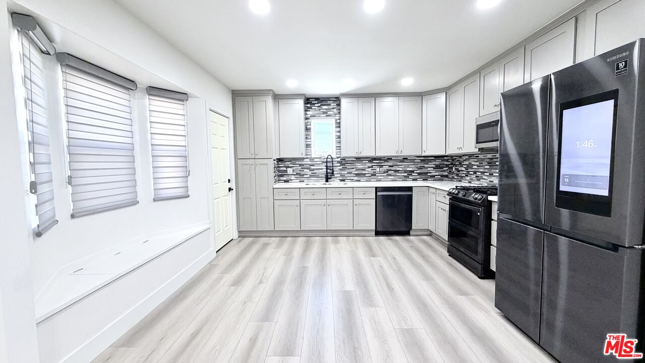 a large kitchen with a stove and refrigerator