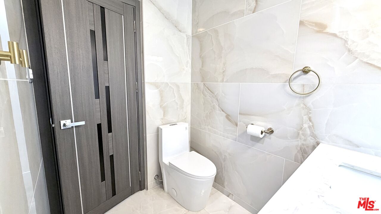 11836 Rialto Street Sun Valley, CA 91352 - Photo 17 of 34 a bathroom with a toilet and a shower curtain