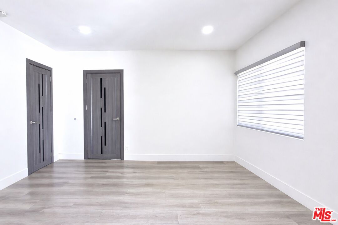 11836 Rialto Street Sun Valley, CA 91352 - Photo 8 of 34 a view of an empty room with wooden floor and a window