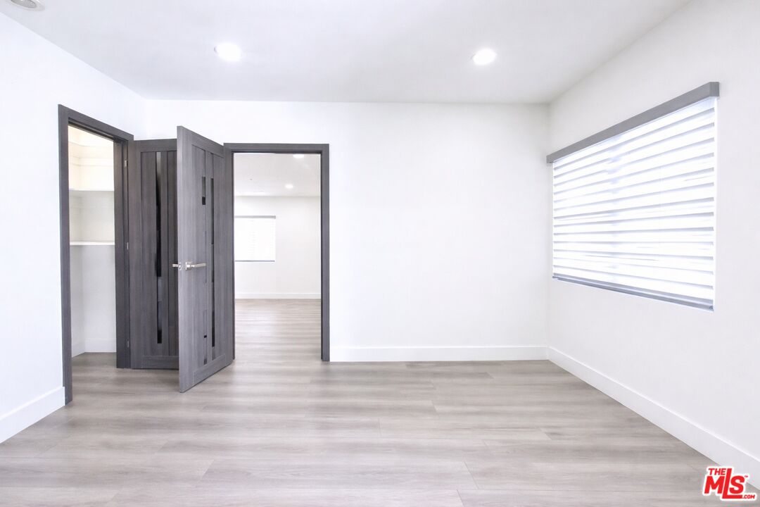 11836 Rialto Street Sun Valley, CA 91352 - Photo 9 of 34 a view of an empty room with wooden floor and a window