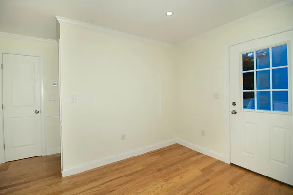 a view of empty room with wooden floor and entryway