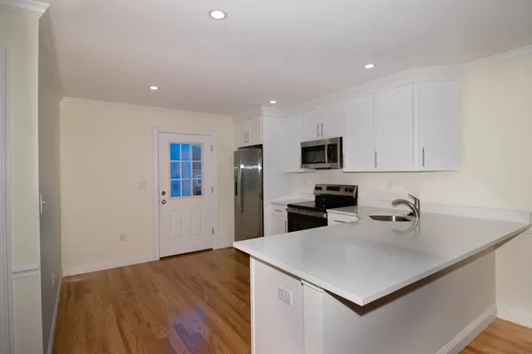 a kitchen with a sink a microwave and cabinets