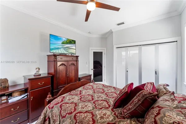 a bed room with a bed a flat screen tv and a chandelier