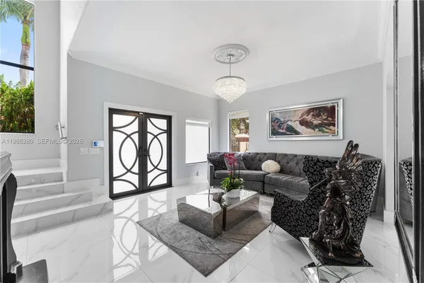 a living room with furniture a fireplace and a chandelier