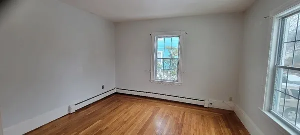 a kitchen with granite countertop a sink dishwasher a stove and white cabinets with wooden floor