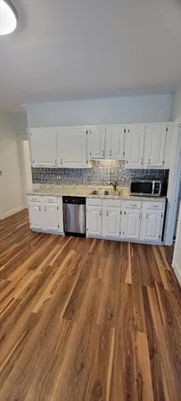a kitchen with white cabinets and a stove top oven