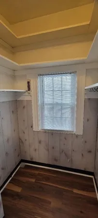 a view of an empty room with closet and wooden floor