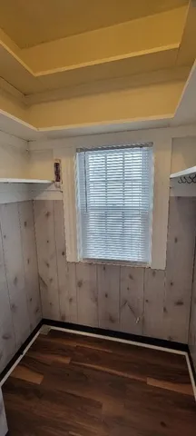 a view of an empty room with closet and wooden floor