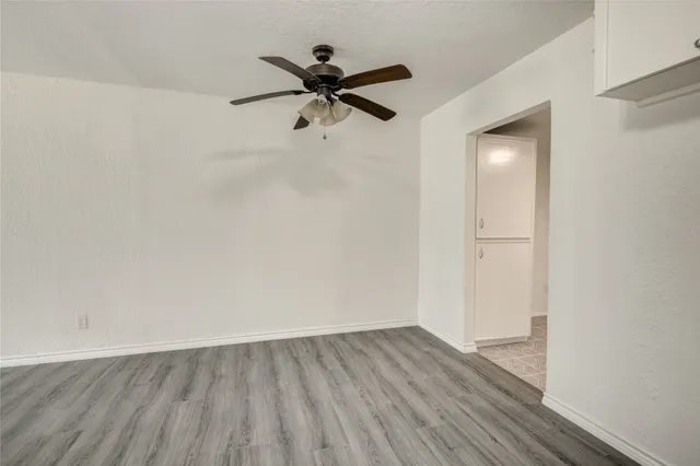 a view of a room with wooden floor and a ceiling fan