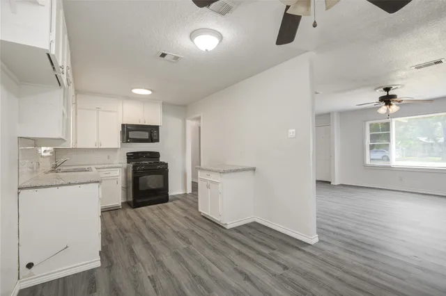 a kitchen with a refrigerator and white cabinets