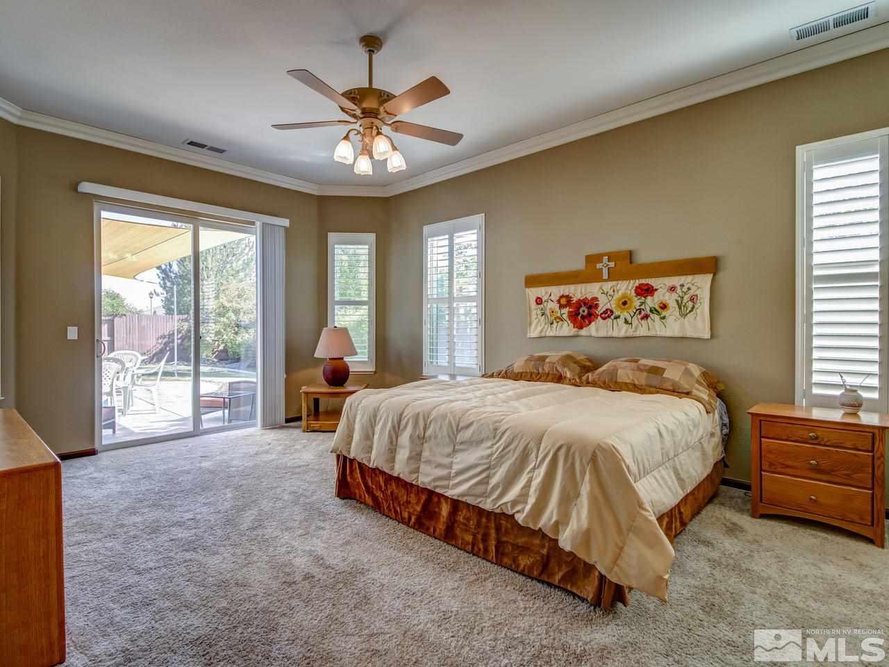 1695 Crater Court Reno, NV 89521 - Photo 11 of 25 a spacious bedroom with a large bed and a chandelier