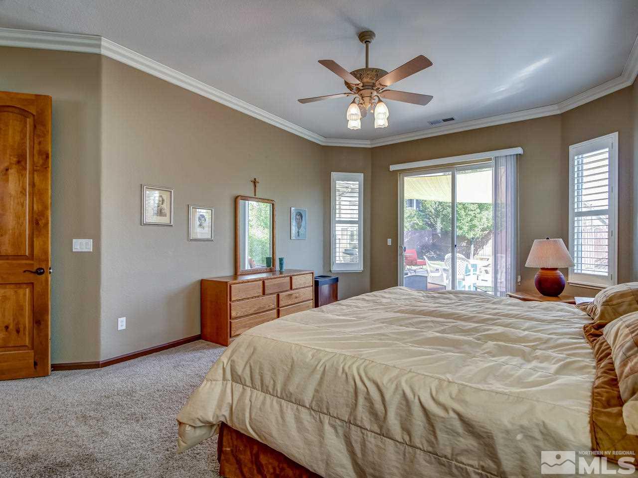 1695 Crater Court Reno, NV 89521 - Photo 12 of 25 a bedroom with a large bed and a chandelier