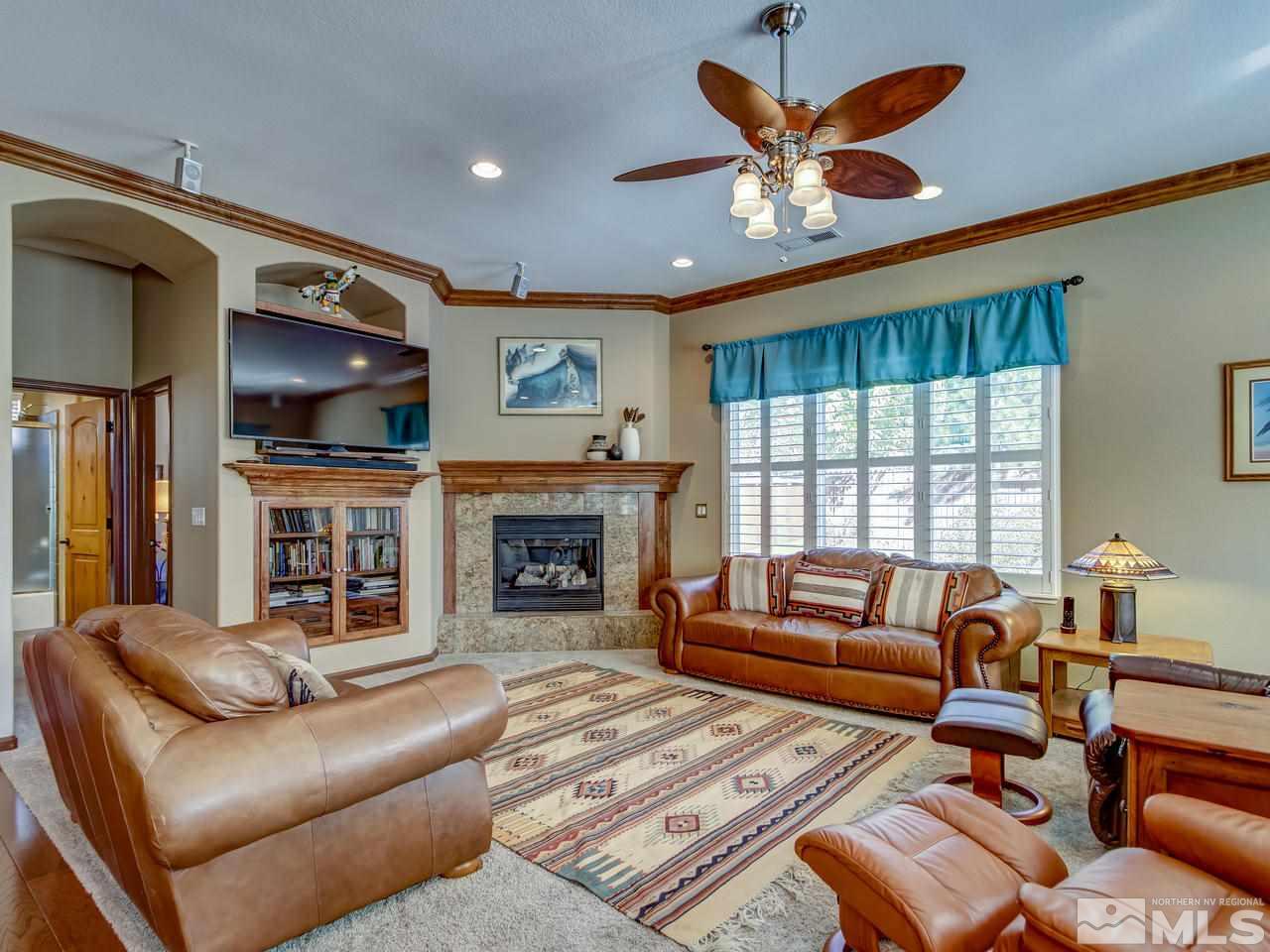 1695 Crater Court Reno, NV 89521 - Photo 3 of 25 a living room with furniture a fireplace and a flat screen tv