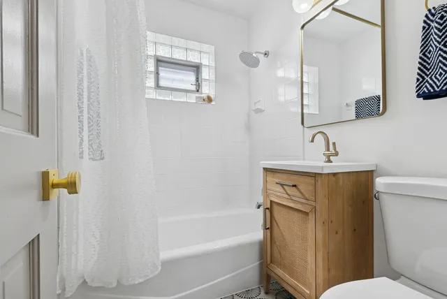 a bathroom with a sink a toilet and shower