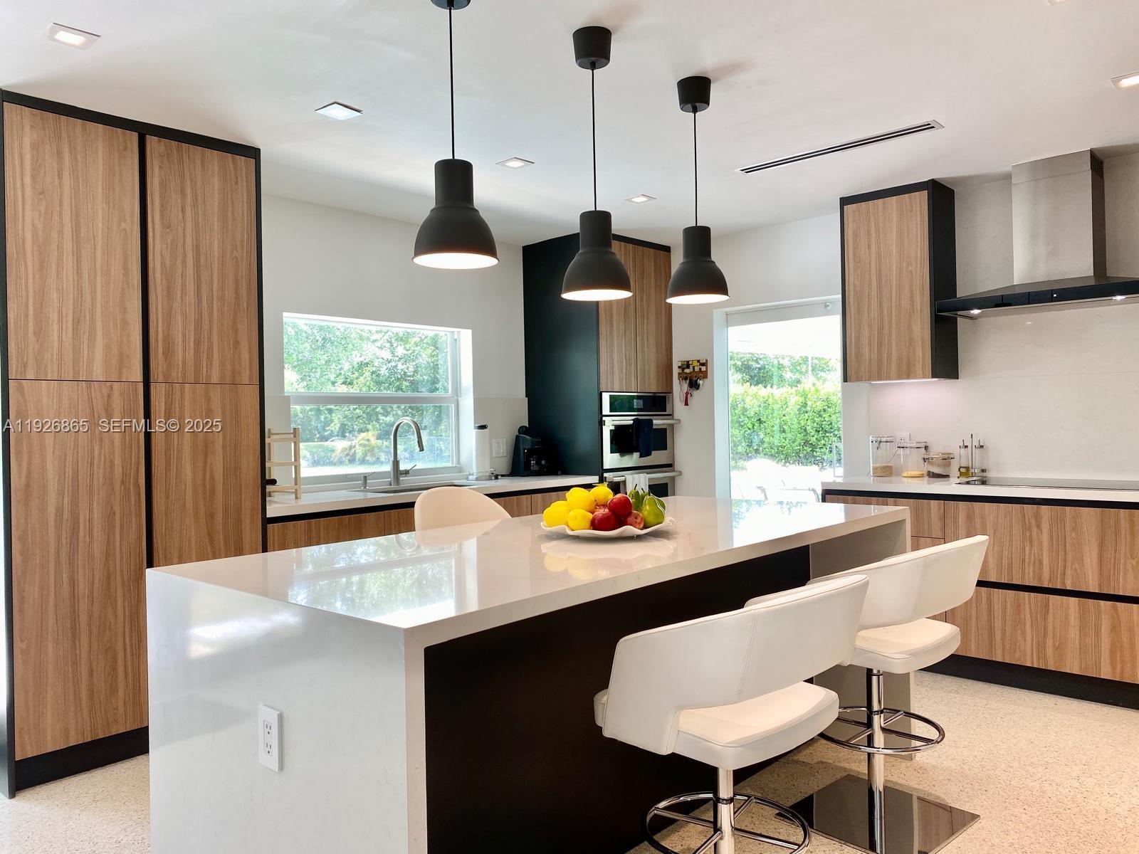 9121 Southwest 85th Street, Unit 2 Miami, FL 33173 - Photo 17 of 26 a kitchen with stainless steel appliances granite countertop a sink a stove a refrigerator and island