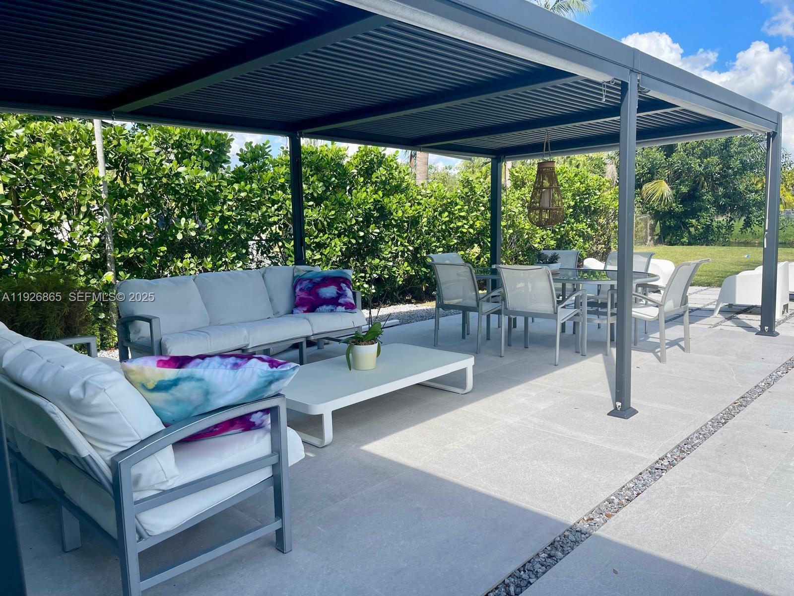 9121 Southwest 85th Street, Unit 2 Miami, FL 33173 - Photo 10 of 26 a outdoor space with the couches and dining table with the garden view