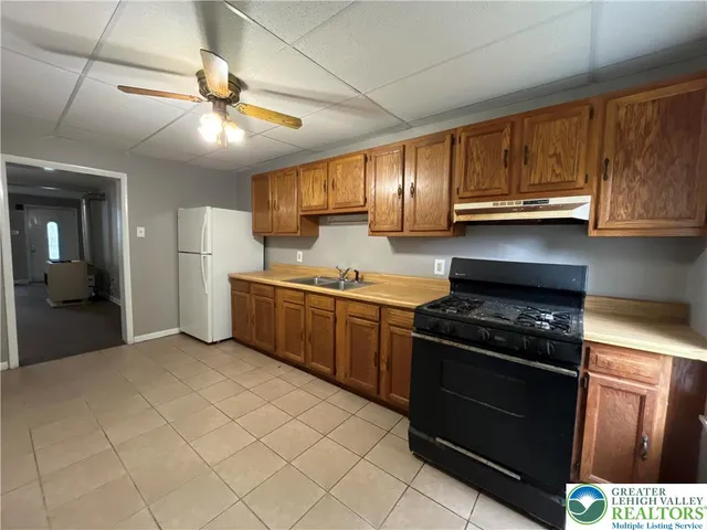 a kitchen with stainless steel appliances granite countertop a stove a sink and a refrigerator