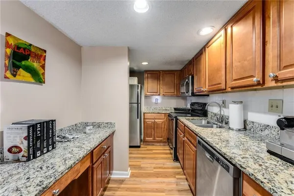 a kitchen with stainless steel appliances granite countertop a stove a sink and a refrigerator