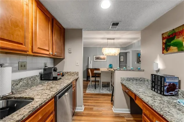 a kitchen with granite countertop a table chairs sink and cabinets