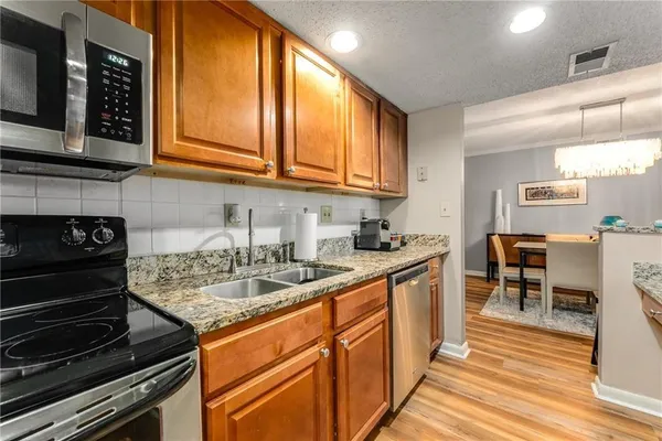 a kitchen with stainless steel appliances granite countertop a stove a sink and a microwave