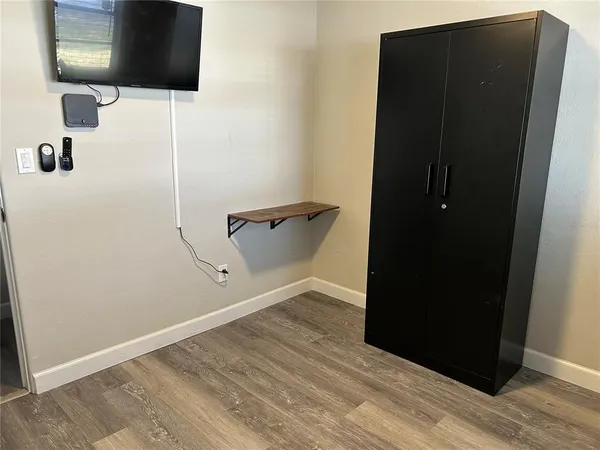 a bedroom with a bed and a flat tv screen on dresser