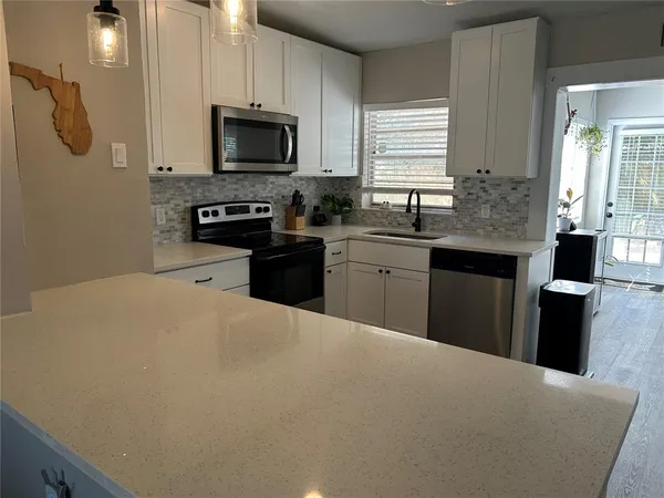 a kitchen with stainless steel appliances a stove sink microwave and cabinets