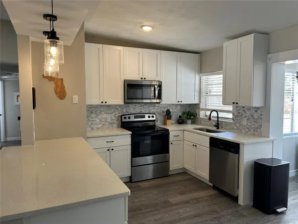 a kitchen with a stove a sink and a microwave