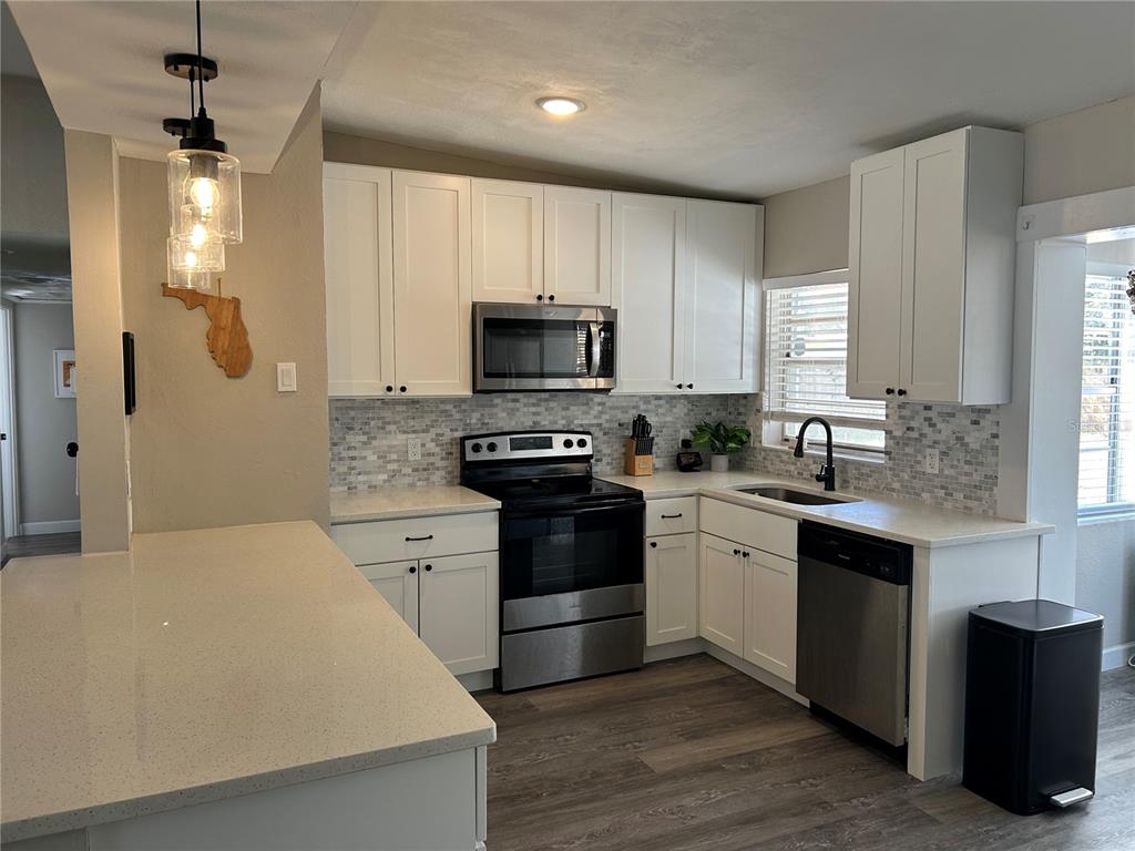 3320 Conway Gardens Road Orlando, FL 32806 - Photo 8 of 21 a kitchen with a stove a sink and a microwave