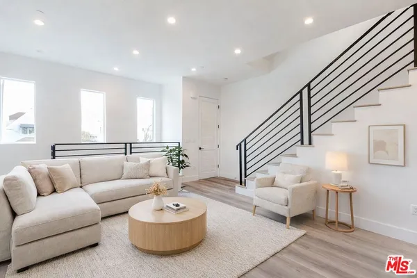 a living room with furniture and stairs