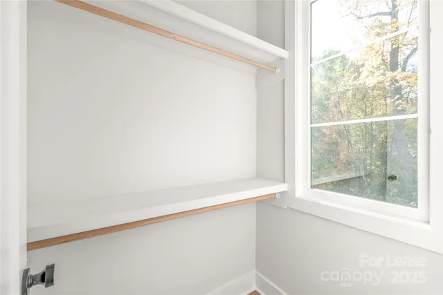 a view of a small space with wooden floor and a window