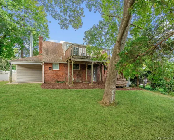 a front view of a house with a garden and trees