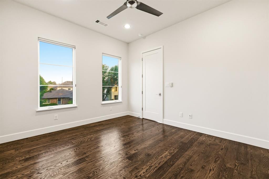 6523 Northwood Road Dallas, TX 75225 - Photo 27 of 36 an empty room with wooden floor chandelier fan and windows