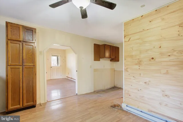 a view of an empty room with window and wooden floor