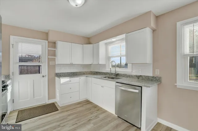 a kitchen with granite countertop white cabinets and white appliances