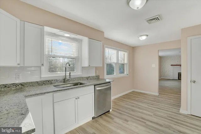 a kitchen with granite countertop cabinets stainless steel appliances a sink and a window