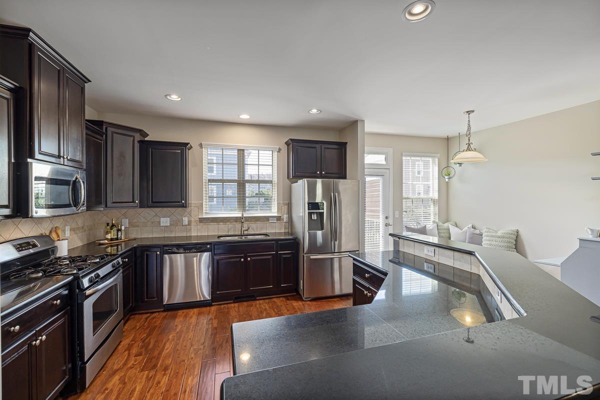 1327 Rembrandt Circle Raleigh, NC 27607 - Photo 11 of 41 a kitchen with stainless steel appliances granite countertop a sink stove and refrigerator