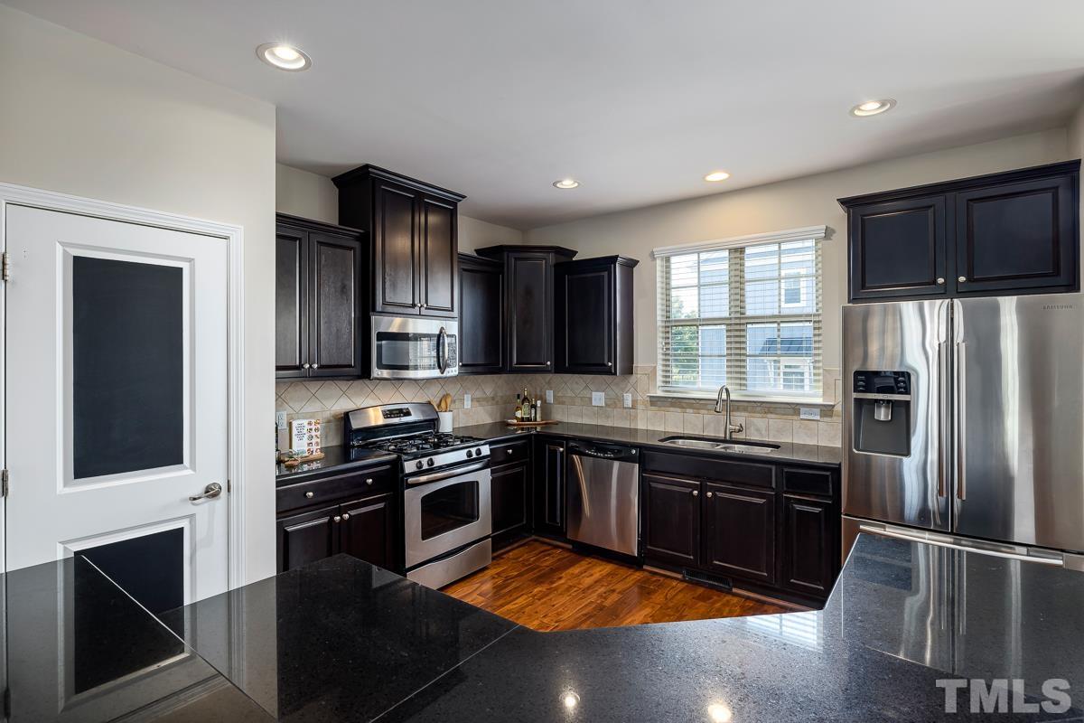 1327 Rembrandt Circle Raleigh, NC 27607 - Photo 12 of 41 a kitchen with stainless steel appliances granite countertop a stove refrigerator and microwave